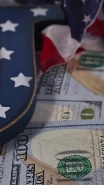 Tokmak ve para birimi gibi Amerikan sembolleri toplumdaki hukuk ve finans arasındaki bağlantıyı vurguluyor.