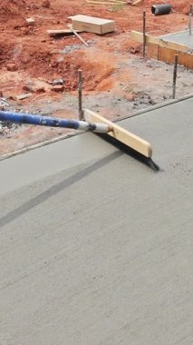 İnşaat alanında inşaat işlemleri ile birlikte süpürge malası ile beton dengeleniyor