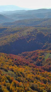 Panoramik bir manzara, rengarenk ağaçlar, yuvarlanan tepeler ve sükunetle dolu nefes kesici bir sonbahar manzarasını gözler önüne serer..