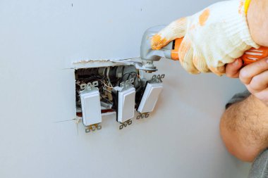 Bireysel çalışmalar, duvardaki çoklu ışık anahtarlarını tamir ederek, düzgün elektrik işlevlerini sağlama alır..