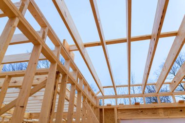 İşçiler ahşap çerçeve yapısı inşa ediyorlar, çatı kerestesi altında kirişleri gösteriyorlar