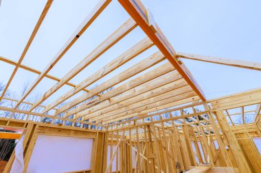 İnşaatçılar, sessiz banliyö ortamında ahşap çerçeve kirişleri çatı kirişleri üzerinde çalışıyorlar..