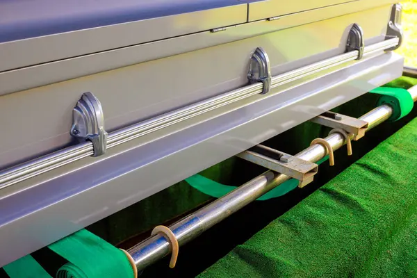 Cenaze tabutu yeşil kadife bir yüzeye yerleştirildi. Mezarlıkta defin töreni için hazırlandı..