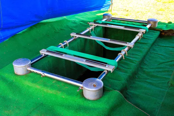 Tabut için gümüş tutucu yeni kazılmış mezarın üzerine yerleştirilir ve defin töreni sırasında sessiz bir çevre oluşur..