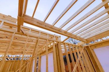 İnşaat ekipleri açık çerçeveli ev için ahşap kirişler monte ediyorlar.