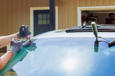 Teknisyen usta bir tamirci araba ön camını bir otomobil hizmet merkezinin dışına yerleştirir..