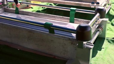 Tabut dikkatlice mezara indirilir. Cenaze töreni sırasında yeşil çim çiçekleriyle çevrilidir.