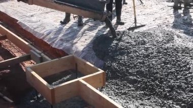 İnşaat ekibi beton levhayı kalıplara döküyor, temelleri şekillendiriyor.