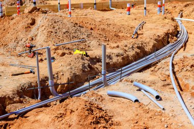 İşçiler inşaat sahasına elektrik tesisatı kuruyor, kamu hizmetleri için zemin hazırlıyorlar.