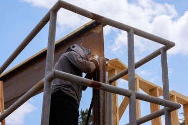 İşçiler, yoğun inşaat sahasında ustalıkla çelik kirişleri kaynaştırıyorlar..