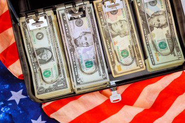 Bir Amerikan bayrağını dinlendirirken evrak çantasında çeşitli banknotlar halinde nakit para düzenlenir..