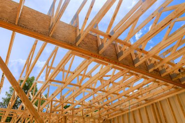 İşçiler temiz gökyüzünün altında yeni ev için ahşap kirişler kuruyorlar..