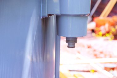 Tesisatçı havuz filtresi sistemi kuruyor. Arka bahçedeki bağlantı göstergelerini kontrol ediyor..