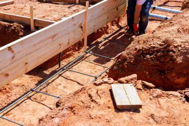 İnşaat işçisi inşaat alanında yeni vakıf için inşaat çubuğu çerçeveleri kuruyor.