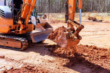 Ağır makineler inşaat alanında çukur kazıyor.