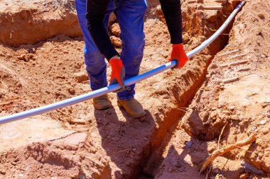 İnşaat işçisi vakıf işi sırasında dolu hendeğe elektrik borusu döşedi