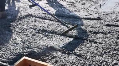 Beton karıştırıcı kamyon tarafından yeni kaldırım için güçlendirilmiş demirlere taze beton dökülüyor.