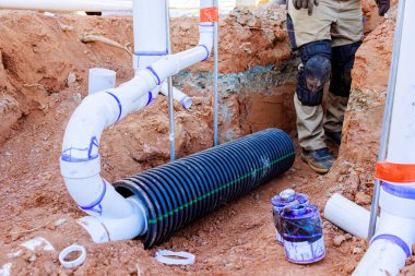 İşçiler sipere kanalizasyon drenaj sistemi kuruyor, tesisat malzemesi inşaatı devam ederken