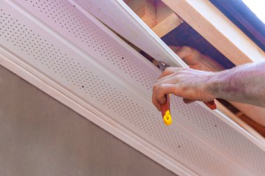 Müteahhit el, iş günü boyunca ev yenileme paneline tavan kurmak için uzanır