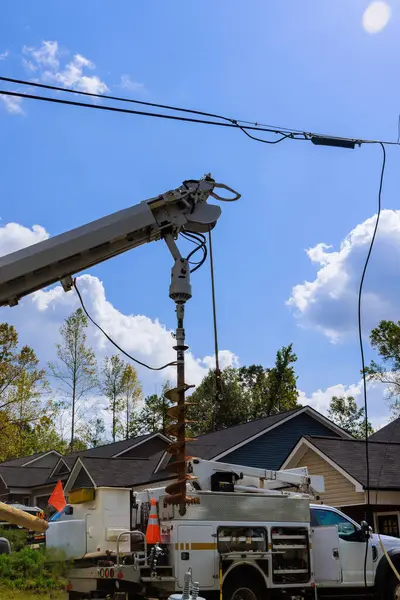 Ağır makineler evlerle çevrili elektrik direklerinin kurulumunda kullanılıyor.