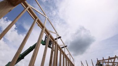 Ağır telgraf makineleri inşaat alanında yeni yapı inşaatı için tahta kirişleri kaldırıyor.