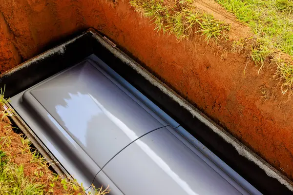 Gri tabut mezarlık kapanmadan önce mezarda yatar. Etrafı toprakla çevrili kasvetli bir atmosfer kaybı ve yas duygusunu uyandırır.