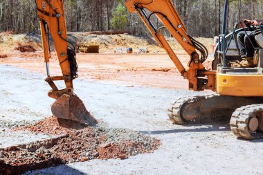 Kazıcı inşaat sahasında verimli çalışıyor, endüstriyel ağır makineler toprağı kazıyor, inşaat faaliyetleri.