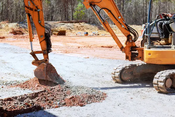 Kazıcı inşaat sahasında verimli çalışıyor, endüstriyel ağır makineler toprağı kazıyor, inşaat faaliyetleri.