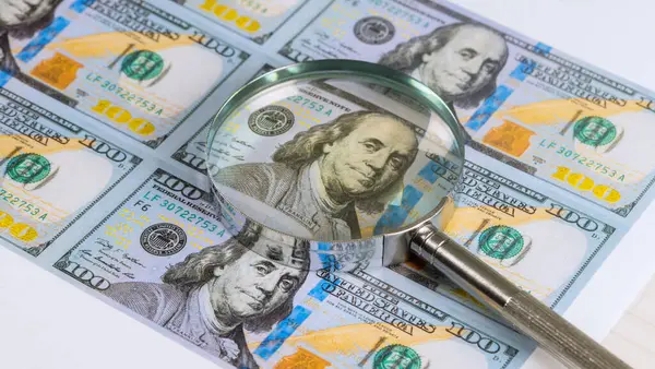 Büyüteç, Benjamin Franklin 'in yer aldığı 100 dolarlık banknotun detaylarını vurguluyor..