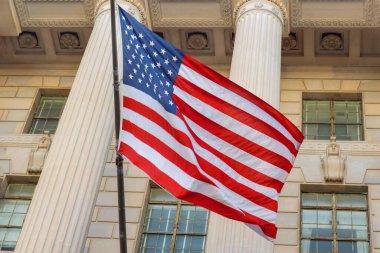 Vatansever Amerikan bayrağı Washington DC 'deki tarihi hükümet yapısının mimari sütunlarının yanında dalgalanmakta.