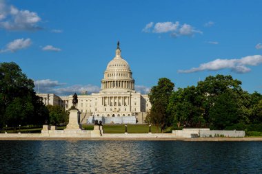 Ziyaretçiler, Washington DC 'deki ağaçlarla çevrili suya yansıyan güneşli günün tadını çıkarıyorlar..