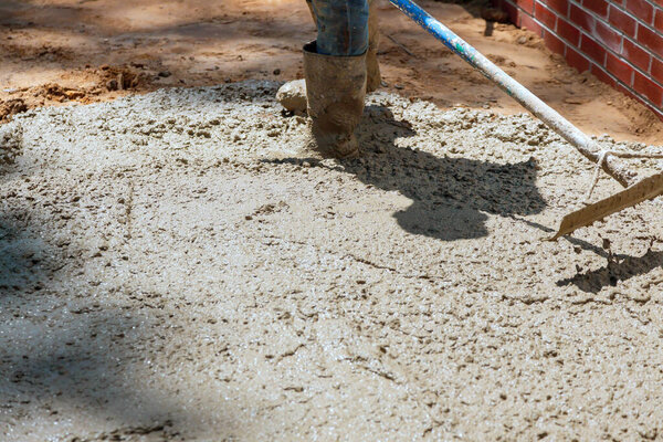 Строители выливают бетонную смесь на поверхность фундамента в течение рабочего дня
