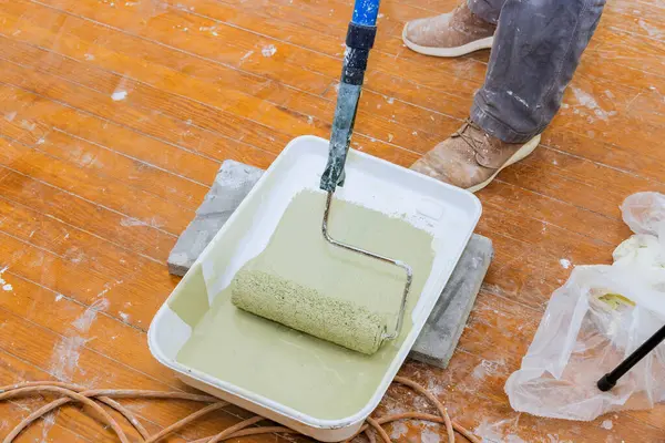 Marangoz, yenilenmiş odaya yeşil boya sürerek son rötuşlara hazırlanıyor..
