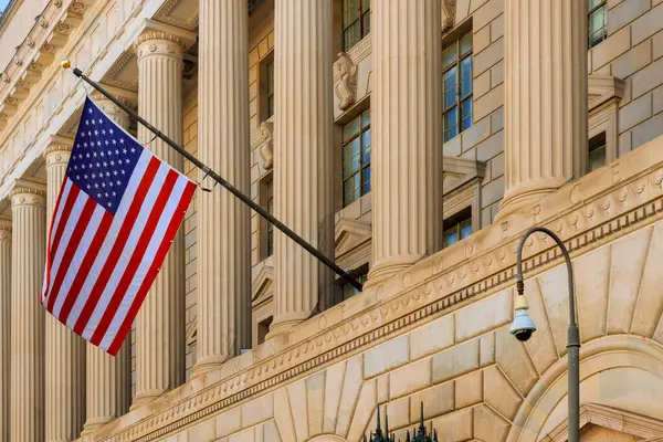 Washington D.C. 'deki zarif sütunların mimari detaylarına karşı Amerikan bayrağı dalgalanıyor