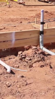 Atık su tesisat boruları iş günü boyunca şantiyenin yeni kazılmış bölgesine yerleştiriliyor.