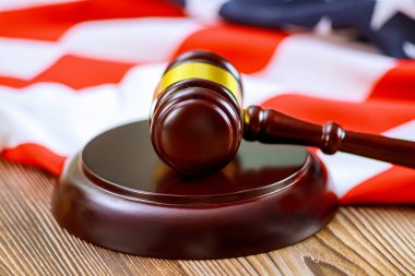 Yargıç Gavel ahşap bir yüzeye yerleştirildi. Arka planda Amerikan bayrağı vardı. Adalet hukukunu simgeliyordu..