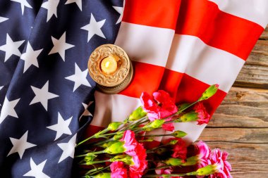 Amerikan bayrağının, pembe çiçeklerin, kırsal ahşap yüzeyde mumların sergilendiği vatanseverliğin kutlanması.