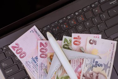 Lira, Türkiye 'de seyahat planlama finans bütçesi öneren nakit para banknotları model uçağın dizüstü bilgisayarda dinlendiğini belirtiyor.