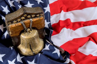 Katlanmış Amerikan bayrağının üzerine ulusal özgürlük temalarını vurgulayan süslü çan hatırlama sembolü konmuştur..
