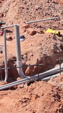 İşçiler inşaat alanındaki hendeğe elektrik boruları döşedi