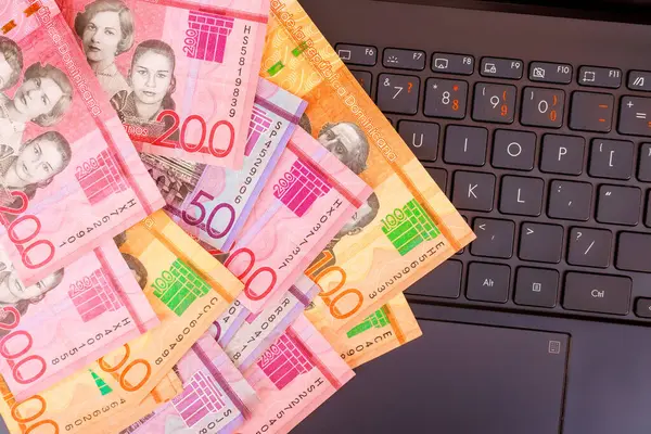 Para birimi Dominik pezosu dizüstü bilgisayardaki banknotlar para teknolojisi arasındaki bağlantıyı gösteriyor..