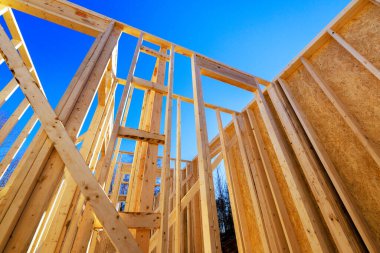 İnşaatçılar inşaat alanındaki yeni ev için ahşap kirişler monte ediyorlar.