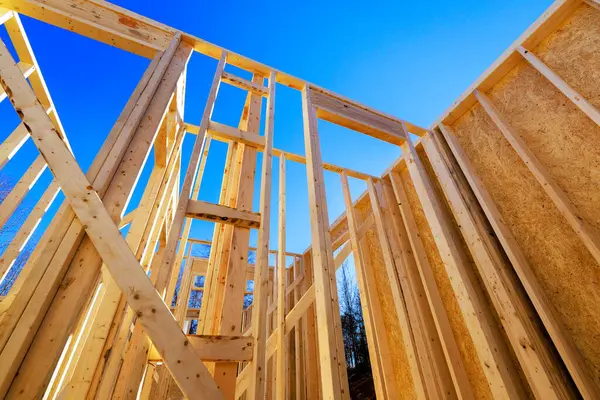 İnşaatçılar inşaat alanındaki yeni ev için ahşap kirişler monte ediyorlar.