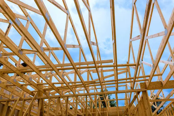 İşçiler ahşap çerçeve yapısı inşa ediyorlar, inşaat alanında kirişlerin karmaşık düzenlenmesi