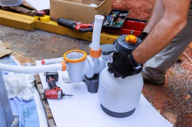 Havuz filtreleme sisteminin bileşenleri arka bahçede, yüzme havuzunun yanında çalışıyor.