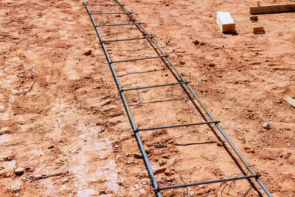Bölgedeki kumlu toprak üzerindeki inşaat iskeleti, beton dökme çalışmalarına hazırlandığını gösteriyor.