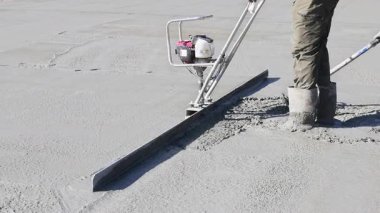 İşçiler ustalıkla inşaat alanında yeni beton döşeme, inşaat alanında takım çalışması uzmanlığı uygularlar.