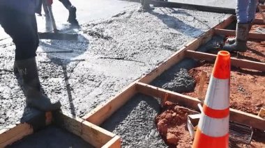 İnşaat işçileri beton döküyor. Çalışma günlerinde temel için ahşap çerçeveler yapıyorlar.