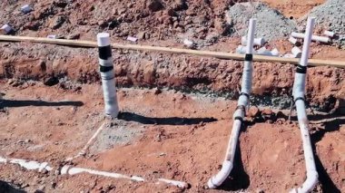 İşçiler yakınlardaki araç kazıcı ekipmanlarıyla yerleşim bölgesine drenaj sistemi kuruyor..