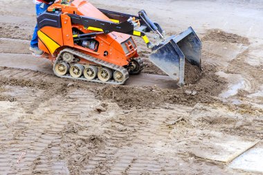 Çalışma gününde inşaat alanında toprak taşımak için kompakt parça yükleyici kullanılır